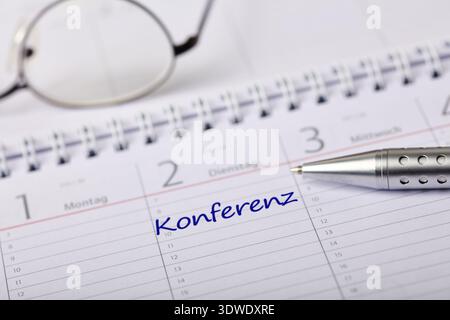 Image montrant un calendrier ouvert avec le mot 'Konferenz' (allemand pour : Conférence) écrit sous une date spécifique. Banque D'Images