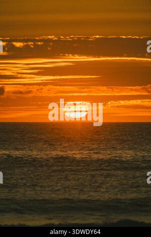 Une vue imprenable sur le coucher de soleil doré sur l'océan Atlantique, projetant des couleurs vibrantes à travers le ciel et la mer en Galice, en Espagne, capturant natu Banque D'Images