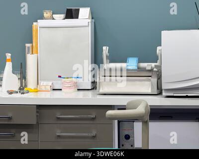 Un cabinet dentaire moderne présente un équipement dentaire détaillé et des outils sur un comptoir blanc, avec un modèle dentaire et une brosse à dents pour les démons patients Banque D'Images
