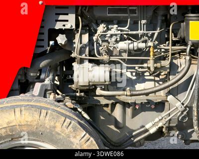 Vue rapprochée du moteur d'un tracteur présentant les détails complexes de ses composants. Mise en évidence de divers tuyaux, fils et structures métalliques uniques à ag Banque D'Images
