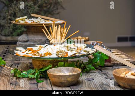 Un plat magnifiquement agencé avec une sélection de fromages assortis, accompagnés de gressins et de noix croquants. Parfait pour les amateurs de gastronomie Banque D'Images