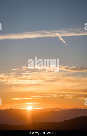 Un coucher de soleil fascinant sur Tibidabo à Barcelone, capturant le soleil plongeant sous l'horizon, peignant le ciel dans des tons orange et rose contre le Banque D'Images