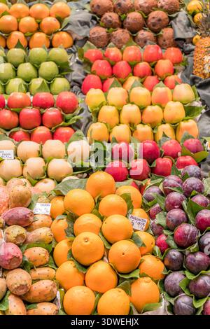 Une exposition vibrante de fruits assortis sur un stand de marché présente une riche variété de couleurs et de textures. Les oranges fraîches, les pommes, les poires et les prunes sont Ar Banque D'Images