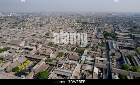 Une photo aérienne de la ville antique de Pingyao à l'intérieur de la ville fortifiée, mettant en valeur l'étendue de l'architecture chinoise traditionnelle et les toits historiques qui ont Banque D'Images