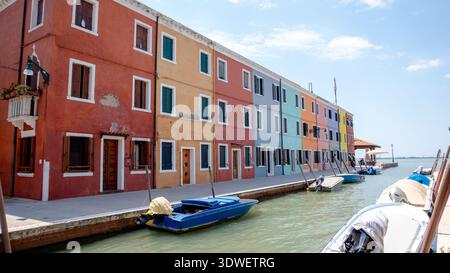 Vue pittoresque de maisons colorées par un canal sur l'île de Burano, situé dans la lagune de Veneta, Venise, Italie. Les bateaux sont amarrés le long de l'eau Banque D'Images