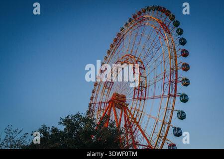 Une grande roue vibrante posée contre un ciel bleu clair à Nha Trang, province de Khanh Hoa, Vietnam. Les cabines colorées offrent une vue captivante sur les loisirs Banque D'Images