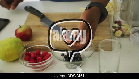 Tri des mains masculines arrangeant les framboises et les bleuets sur le comptoir de cuisine léger, avec un couteau Banque D'Images