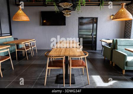 Intérieur contemporain du restaurant avec tables en bois et salle à manger moderne et confortable Banque D'Images