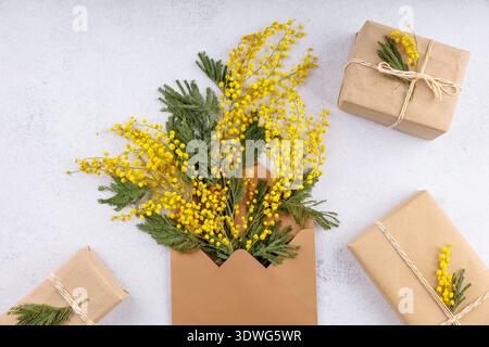 Bouquet de mimosa jaune dans une enveloppe avec emballage cadeau rustique Banque D'Images