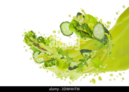 Flux de jus de légumes verts frais verser dans l'air avec des verts feuillus volants, tranches de concombre, éclaboussures, flux de jus d'explosion, tourbillon, isolé. La santé Banque D'Images
