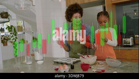 Mélange parent-enfant portant des tabliers orange vert remuant la pâte dans la cuisine, avec superposition de graphique Banque D'Images