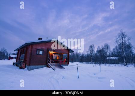 Coucher de soleil sur le lac Inari gelé avec des arbres couverts de neige en Laponie, Finlande près d'Ivalo Banque D'Images