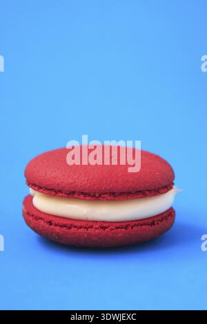 Macaron Red Cake ou macaron sur fond bleu. biscuits aux amandes colorés. Gros plan sur un gâteau aux macarons français. Macarons sur fond coloré Banque D'Images