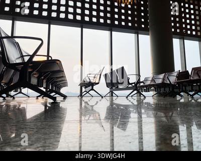 La salle d'attente de l'aéroport dispose de sièges modernes avec de grandes fenêtres offrant une vue panoramique sur l'extérieur et un sol en marbre poli Banque D'Images
