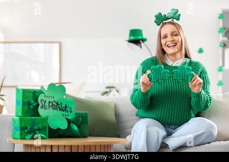 Rousse jeune femme avec des lunettes en forme de trèfle à la maison le jour de Patrick Banque D'Images