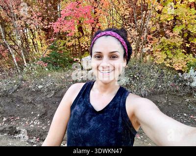 Portrait d'une femme souriante en vêtements de sport sur un sentier de randonnée prenant un selfie, Bells Canyon Hiking Trail, Bells Canyon, Sandy, Utah, USA Banque D'Images