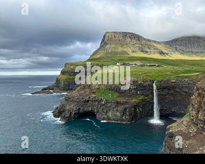 Chute d'eau de Múlafossur dans l'océan Atlantique depuis une falaise près du village de Gásadalur, Vágar, îles Féroé, août 2023 Banque D'Images