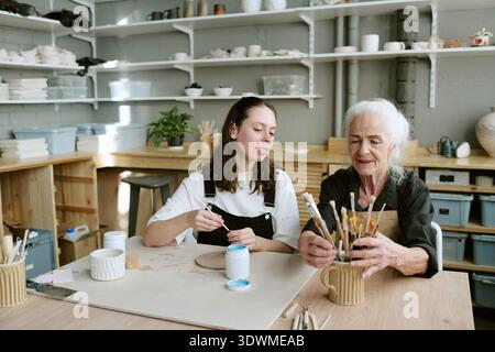 Femme senior et jeune femme adulte peignant ensemble Banque D'Images
