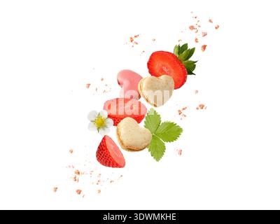 Macarons doux macarons en forme de coeur, tranches de fraises et miettes volant isolé sur fond blanc. Biscuits français à la vanille et à la fraise Banque D'Images