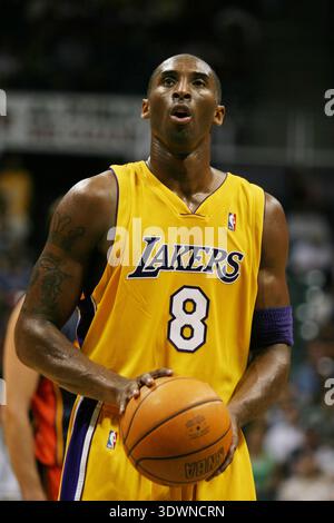 Kobe Bryant des Lakers de Los Angeles est capturé au milieu du match, se concentrant intensément tout en tenant un ballon de basket-ball, se préparant probablement pour un lancer franc en 2005. Il porte son emblématique maillot jaune et violet numéro 8 Lakers, participant activement à un match de basket-ball. L'image illustre magnifiquement son comportement concentré et sa musculature pendant ses meilleures années de jeu. Banque D'Images