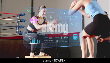 Athlète squatting dans les vêtements de sport faisant des sauts de boîte sur boîte plyo en bois, cordes d'anneau, HUD holographique Banque D'Images
