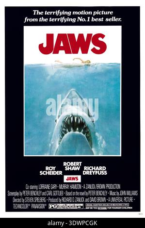 Cette affiche de film emblématique de 1975 pour « Jaws », conçue par Roger Kastel, illustre de façon spectaculaire un grand requin blanc massif qui s'élève des profondeurs pour attaquer un nageur sans méfiance. L'œuvre évoque un sentiment de terreur et de suspense, capturant parfaitement l'essence du film à succès réalisé par Steven Spielberg. Banque D'Images