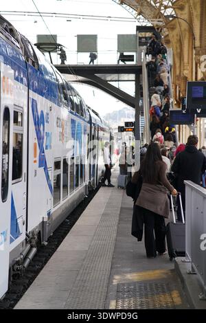 Plate-forme occupée avec ZOU ! Train à impériale et passagers embarquant à la Gare de Nice-ville, toit historique et foule, gare de Nice Côte d'Azur. Banque D'Images