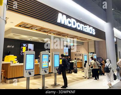 Istanbul, Turquie - 20 octobre 2025 : emplacement McDonald's à l'intérieur de l'aéroport d'Istanbul avec kiosques numériques pour les commandes et les clients qui font la queue pour se Banque D'Images