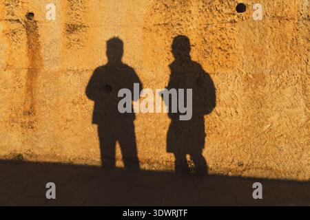 Silhouettes d'un couple marchant au coucher du soleil dans Shaxi Ancient Town près de Dali, Yunnan, Chine. Banque D'Images