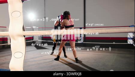 Le trading frappe deux boxeurs féminins en short rose vif et couvre-chef en ring de boxe, avec des formules Banque D'Images
