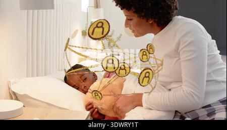 Femme adulte penchée portant plaid-PJS nichant enfant sur le lit avec peluche, AR icônes montrant la lettre A. Banque D'Images