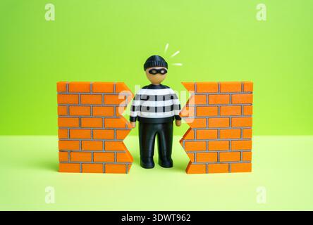 Un criminel trouve un trou dans le mur. Le concept de détection d'une vulnérabilité dans la sécurité. Faiblesses du système et risques de violation. Cybersécurité, formation des forces de l'ordre et discussions sur la sécurité. Banque D'Images