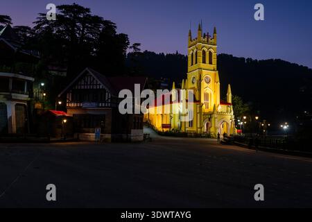 La Christ Church, éclairée en jaune, se détache sur le ciel sombre du soir à The Ridge à Shimla. Banque D'Images