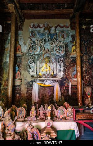 À l'intérieur du Nako Gompa, de nombreuses petites statues bouddhistes et de grandes figures sont disposées devant d'anciennes peintures murales détaillées sur les murs du temple altérés. Banque D'Images