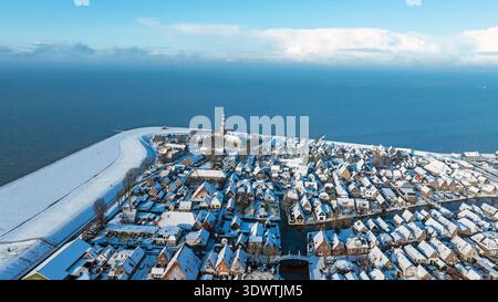 Vue aérienne de la petite ville historique enneigée par le lac en hiver Banque D'Images