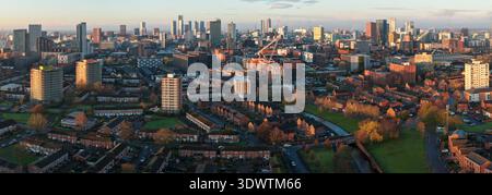Image aérienne vue vers l'ouest de Miles Platting à travers Ancoats vers le centre-ville de Manchester au lever du soleil. Banque D'Images