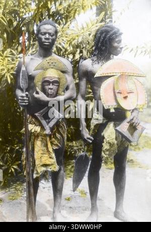 Les hommes Kota sont membres d'un groupe ethnique dans l'actuel Gabon connu pour les figures reliquaires ancestrales mbulu-ngulu utilisées dans les rituels de protection spirituelle. La photographie d'archives de 1917 documente des individus portant un tissu d'écorce et tenant des personnages de gardiens rituels pour l'étude ethnographique. Banque D'Images