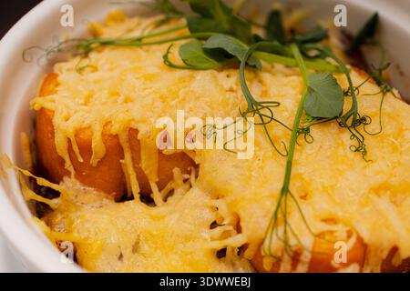 La soupe à l'oignon dans un bol blanc semble délicieuse, avec du fromage frit sur le dessus Banque D'Images