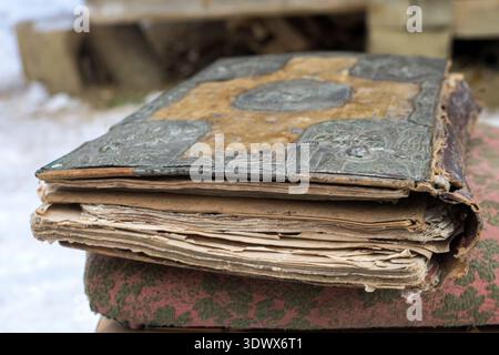 Acheter des livres anciens. Les livres vintage sont empilés sur une table en bois. Restauration de vieux livres. Un vieux livre déchiré a besoin de restauration. Banque D'Images