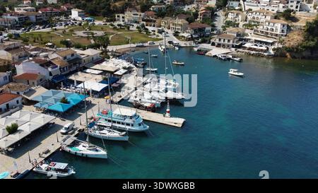 Vue aérienne de la marina de Sivota et du centre-ville, Grèce. Tir par drone du port local avec un phare, des bateaux amarrés et des maisons en bord de mer en été. Banque D'Images
