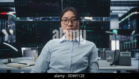 Négociante asiatique ciblée dans le bureau innovant de la Bourse. Femme travaillant poste de travail de haute technologie avec des moniteurs. Concept de leadership féminin et expertise dans massive Digital Finance Hub. Portrait. Banque D'Images