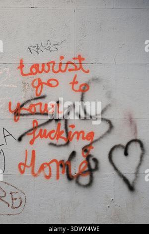 Graffiti avec les mots : touriste aller à votre maison sanglante sur un mur dans la vieille ville de Valence Banque D'Images