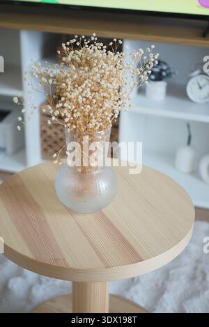 Fleurs séchées dans un vase sur une table en bois Banque D'Images