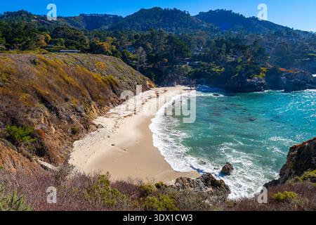 Vue imprenable sur les eaux turquoises vives et la petite plage de sable nichée entre les falaises rocheuses de China Cove à point Lobos Banque D'Images