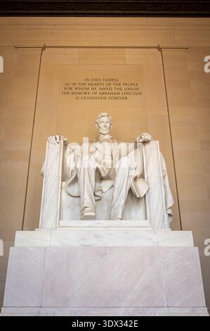 La photographie capture une image puissante et sereine de la statue d'Abraham Lincoln, baignée de lumière douce dans une salle monumentale. La composition emphas Banque D'Images