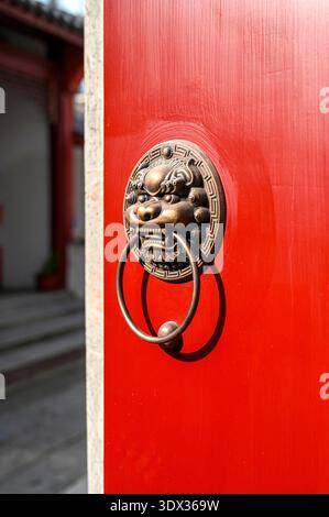 Porte traditionnelle chinoise en bois rouge avec poignée en fer, image verticale Banque D'Images