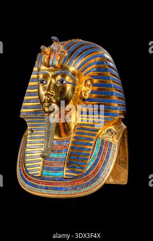Masque doré emblématique de Toutchamon, également connu sous le nom de Roi Tut, ancien pharaon égyptien. Coiffe royale détaillée et symboles de l'Égypte ancienne isolés sur Banque D'Images