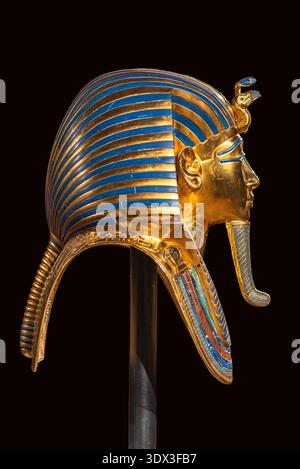 Profil latéral du masque funéraire doré de Toutankhamon, connu sous le nom de King Tut, ancien pharaon égyptien. Coiffe détaillée de Nemes et symboles royaux isolés Banque D'Images