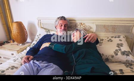 Couple senior partageant des moments intimes heureux au lit Banque D'Images