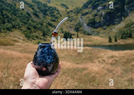 Moment de détente avec Yerba Mate dans la vallée alpine immaculée et le lac de montagne Banque D'Images